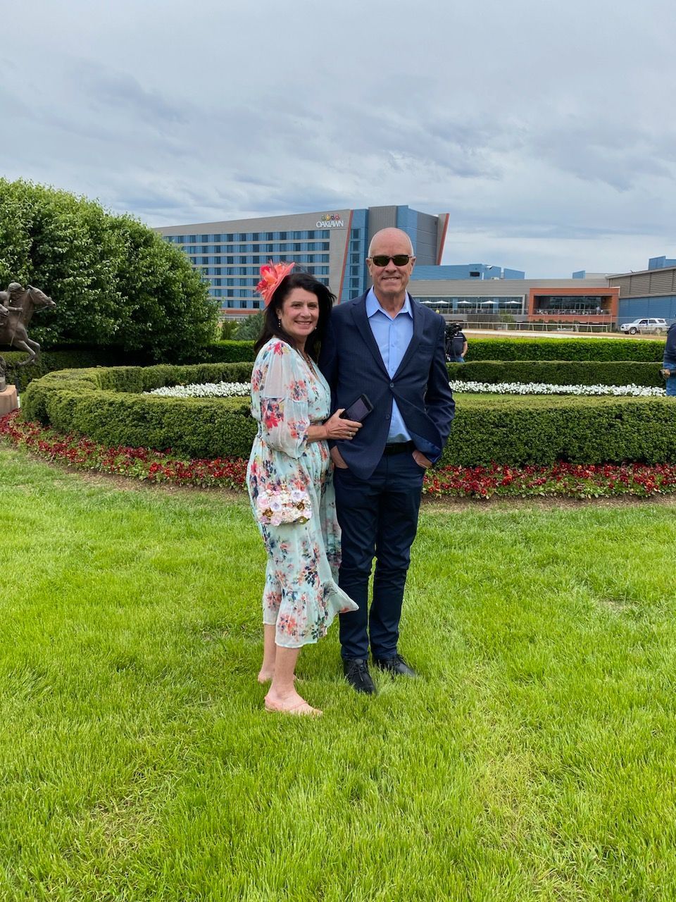 A man and a woman are posing for a picture in the grass.