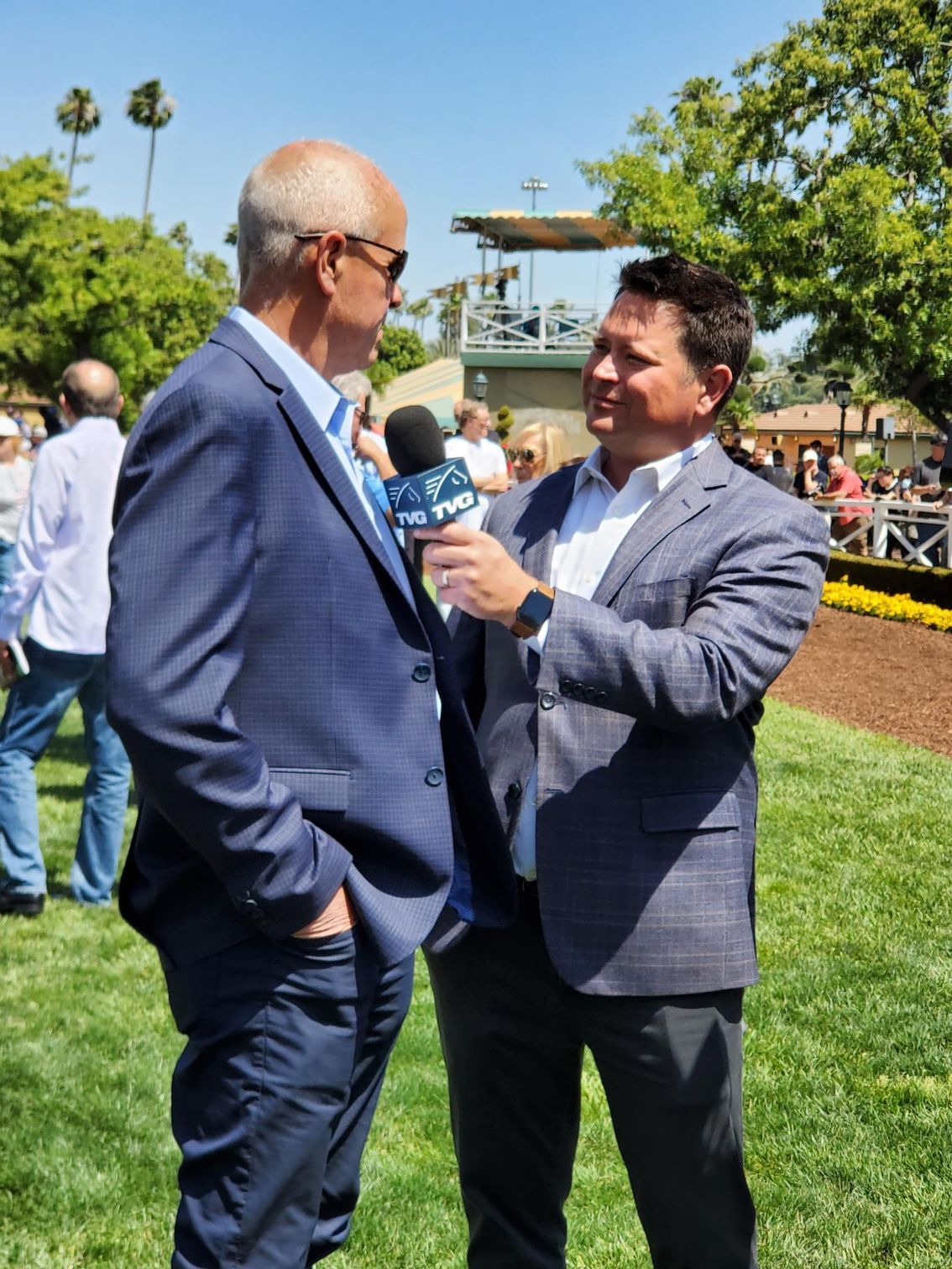 A man in a suit is talking to another man with a microphone