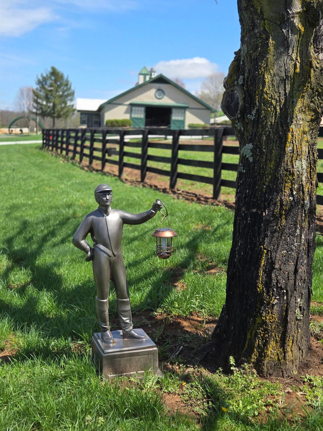 A statue of a man holding a lantern in a field