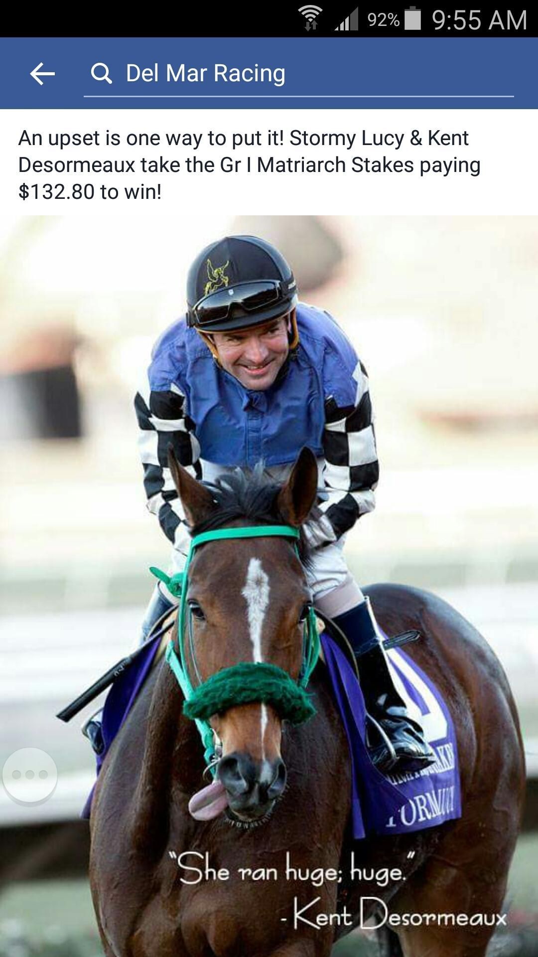 A jockey is riding a horse on a race track.