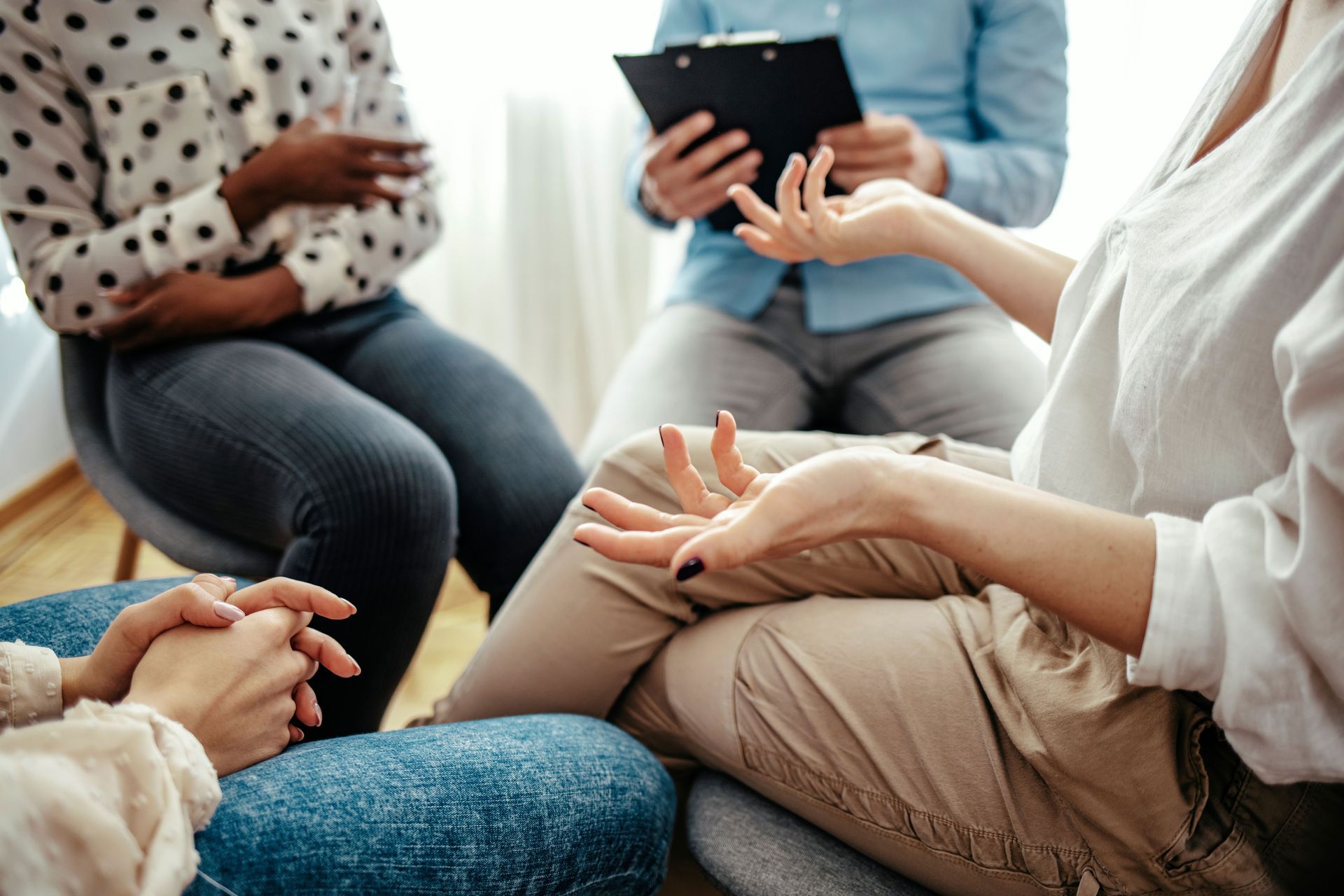 A group of people are sitting in a circle talking to each other.