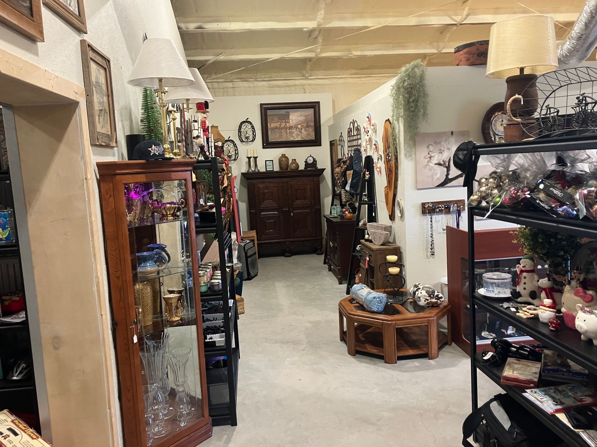 An antique store interior with display cabinets, furniture, and various items for sale.