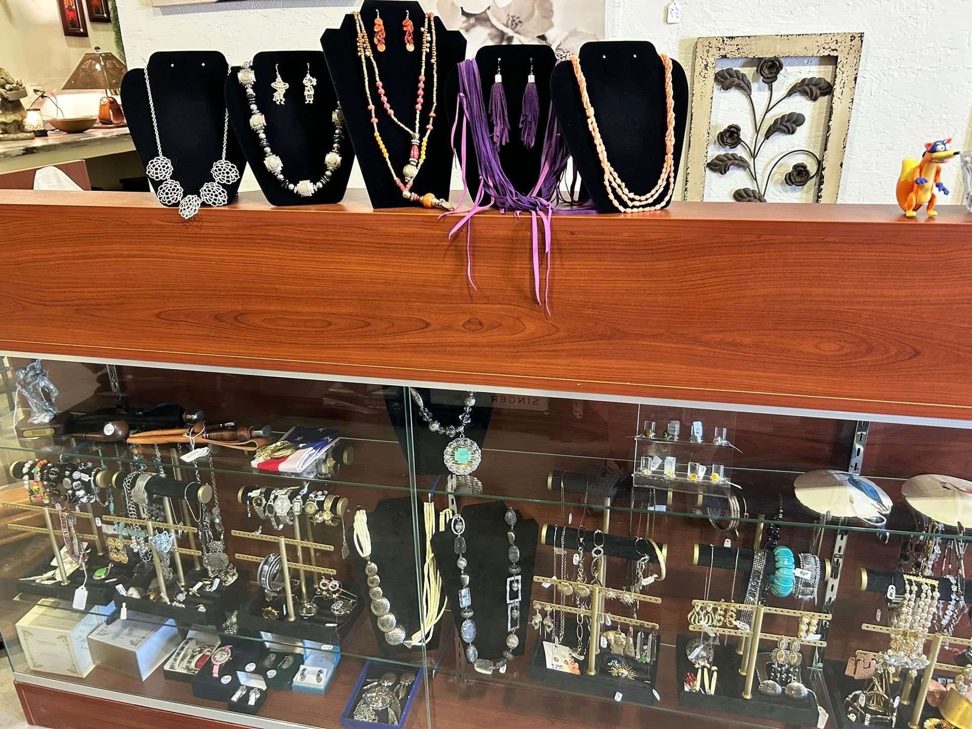 Jewelry display with necklaces and earrings in a store setting.