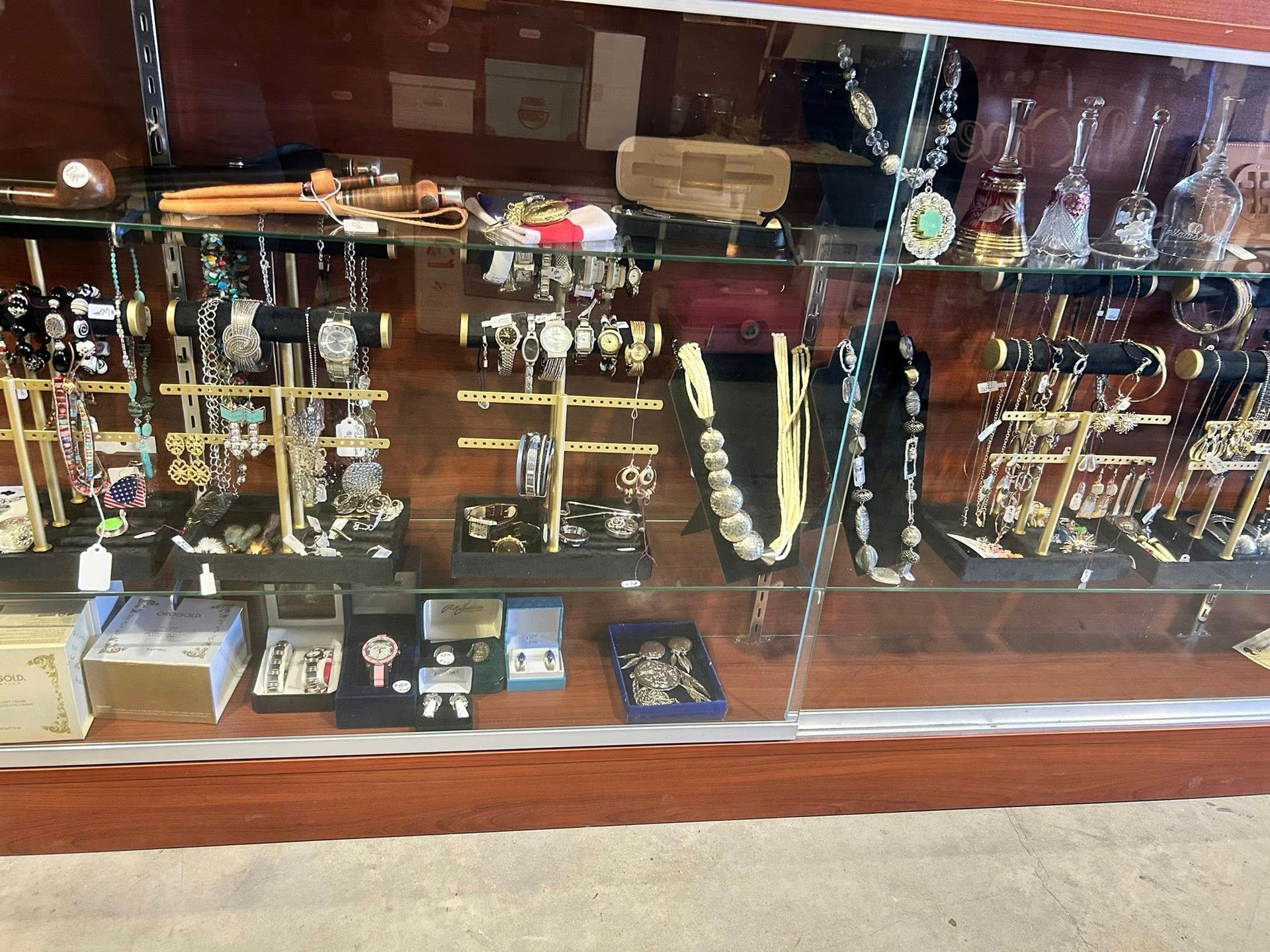 Jewelry display case with watches, necklaces, and rings, displayed on stands in a store.