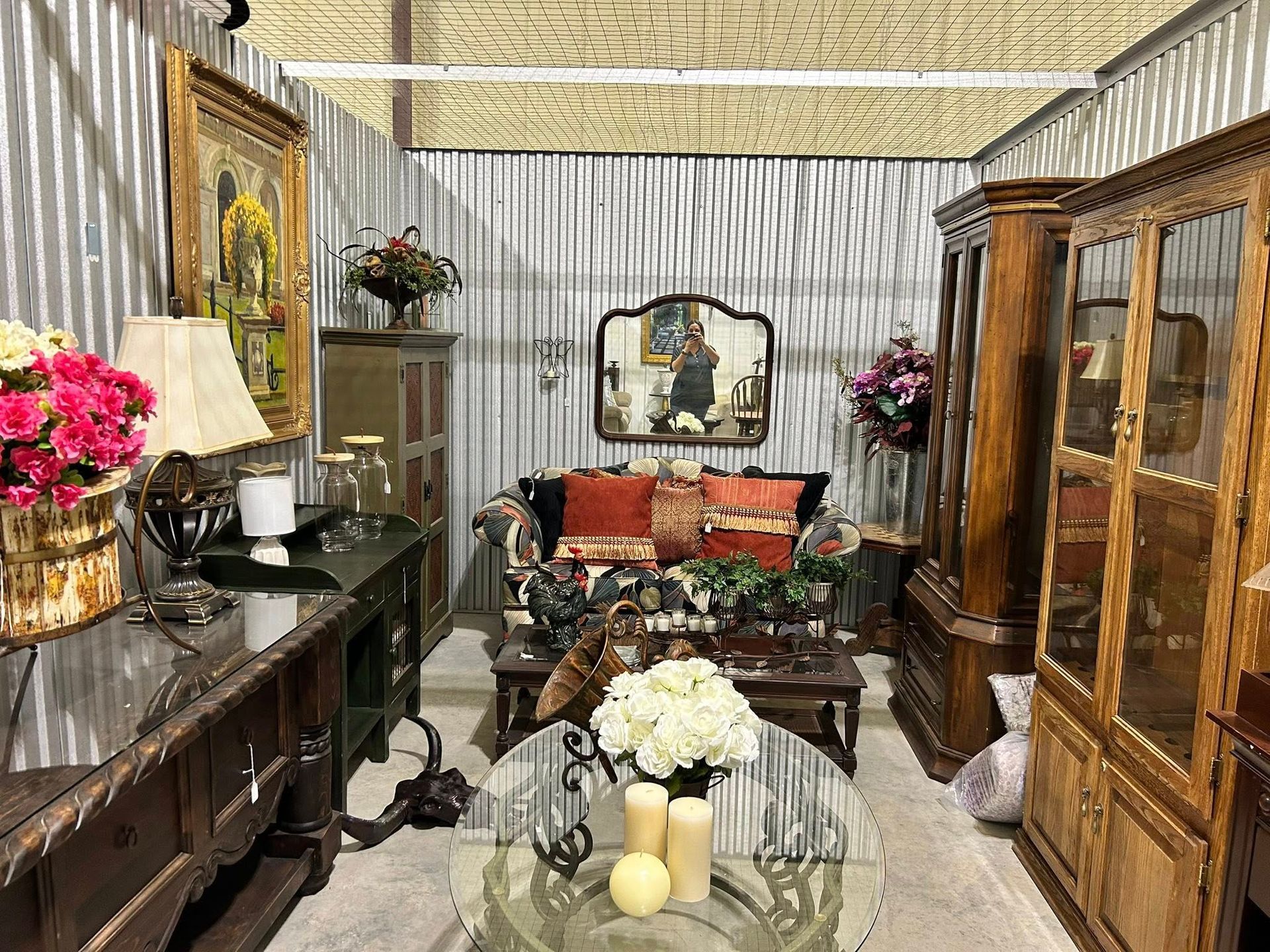 An antique furniture display. Living room setting with couch, cabinets, and decorative items.