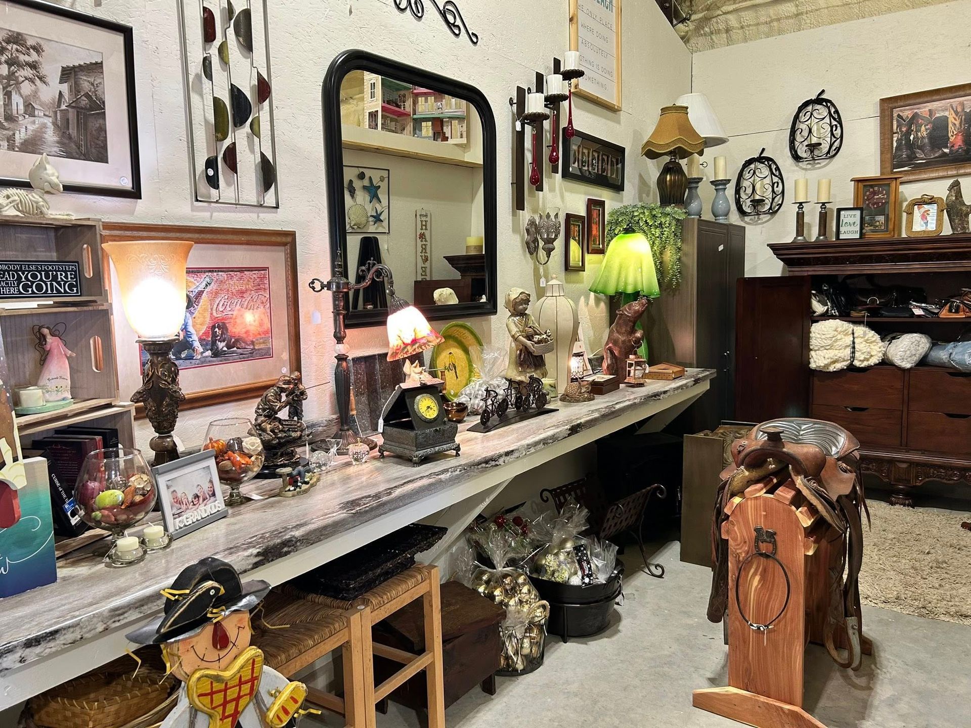 A room filled with various antiques and decorations on a long counter with a mirror.