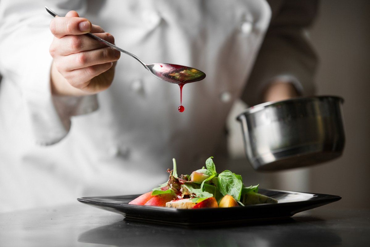 A chef putting sauce on a dish
