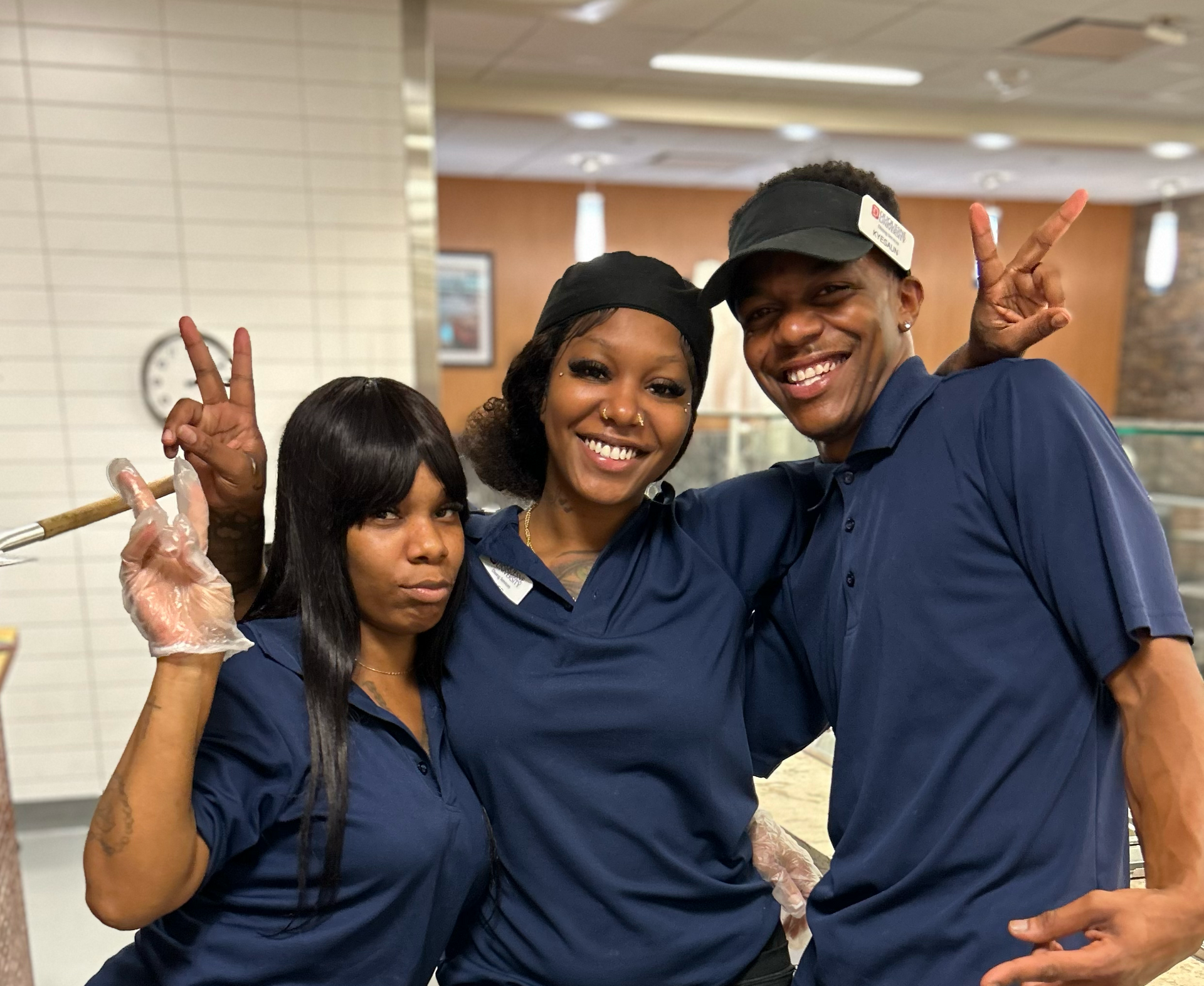 Three team members smiling and posing for a photo.