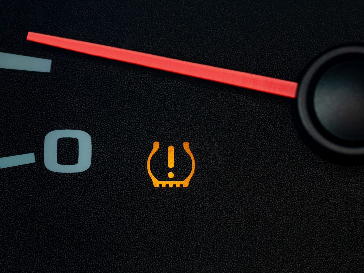Tire pressure warning light, yellow, illuminated on a car dashboard, with an exclamation point symbol.