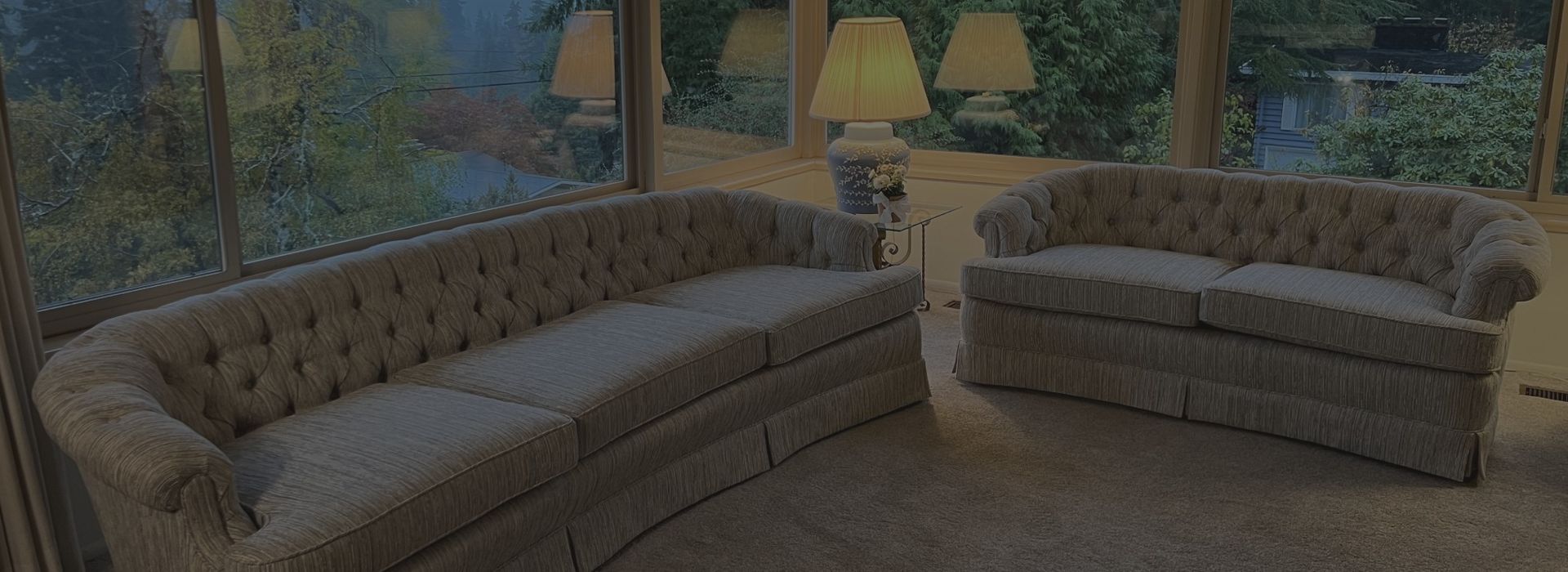 A living room with two couches and two lamps.