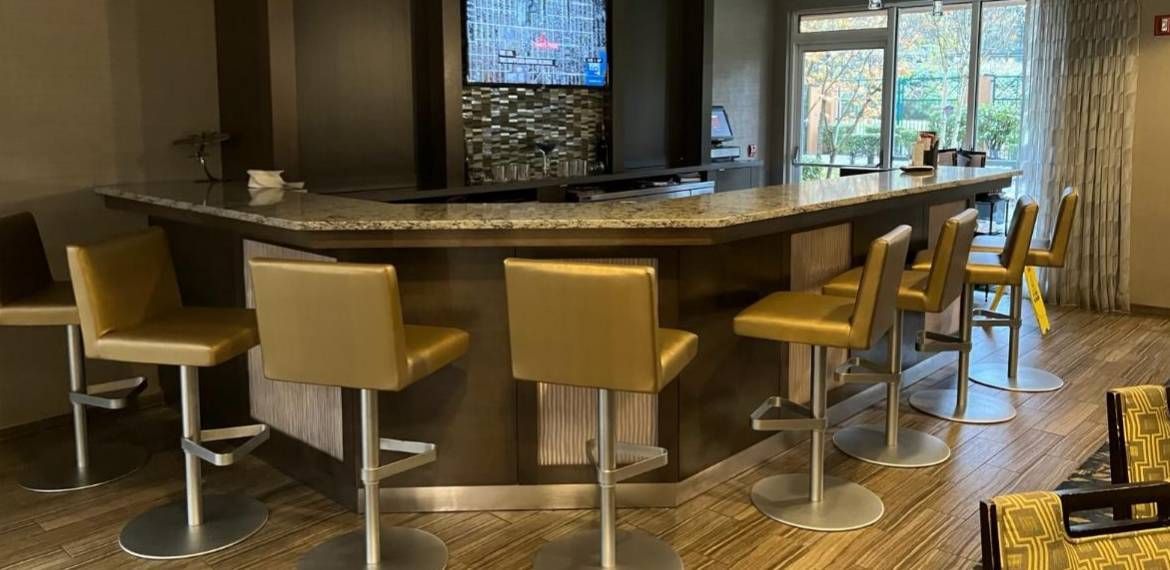 A bar with stools and a television in a living room.