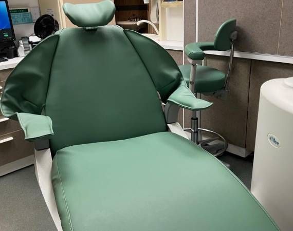 A green dental chair in a dental office