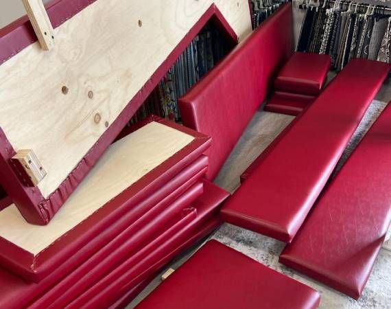 A bunch of red cushions are stacked on top of each other