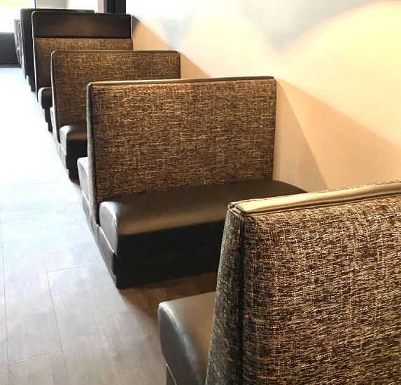 A row of booths are lined up in a restaurant.