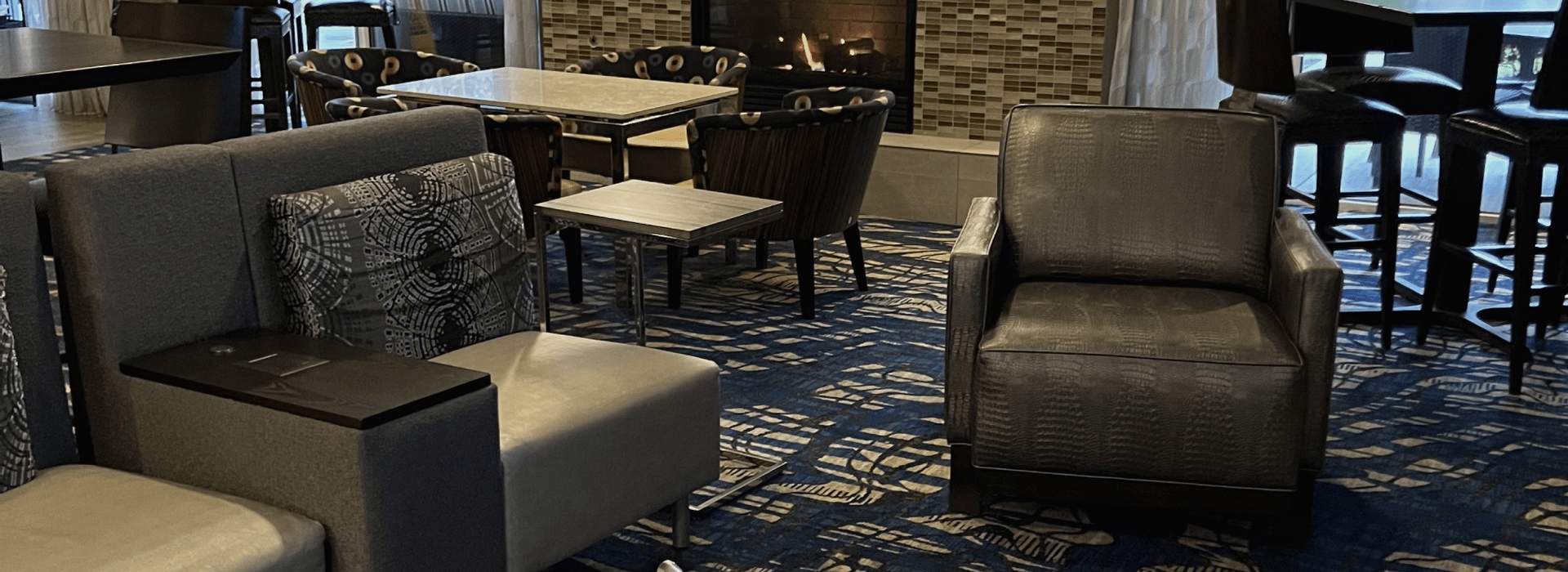 A living room with a fireplace , chairs , tables and a couch.