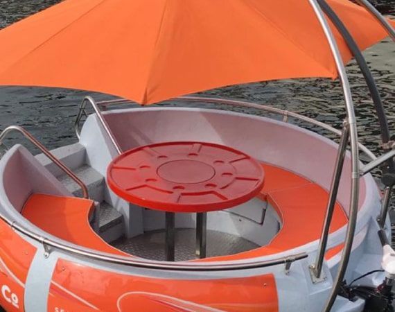 A boat with a red table and an orange umbrella