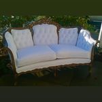 A white couch is sitting on top of a wooden table.