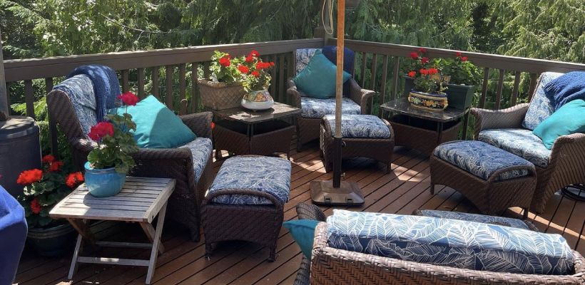 A wooden deck with wicker furniture and a patio umbrella.