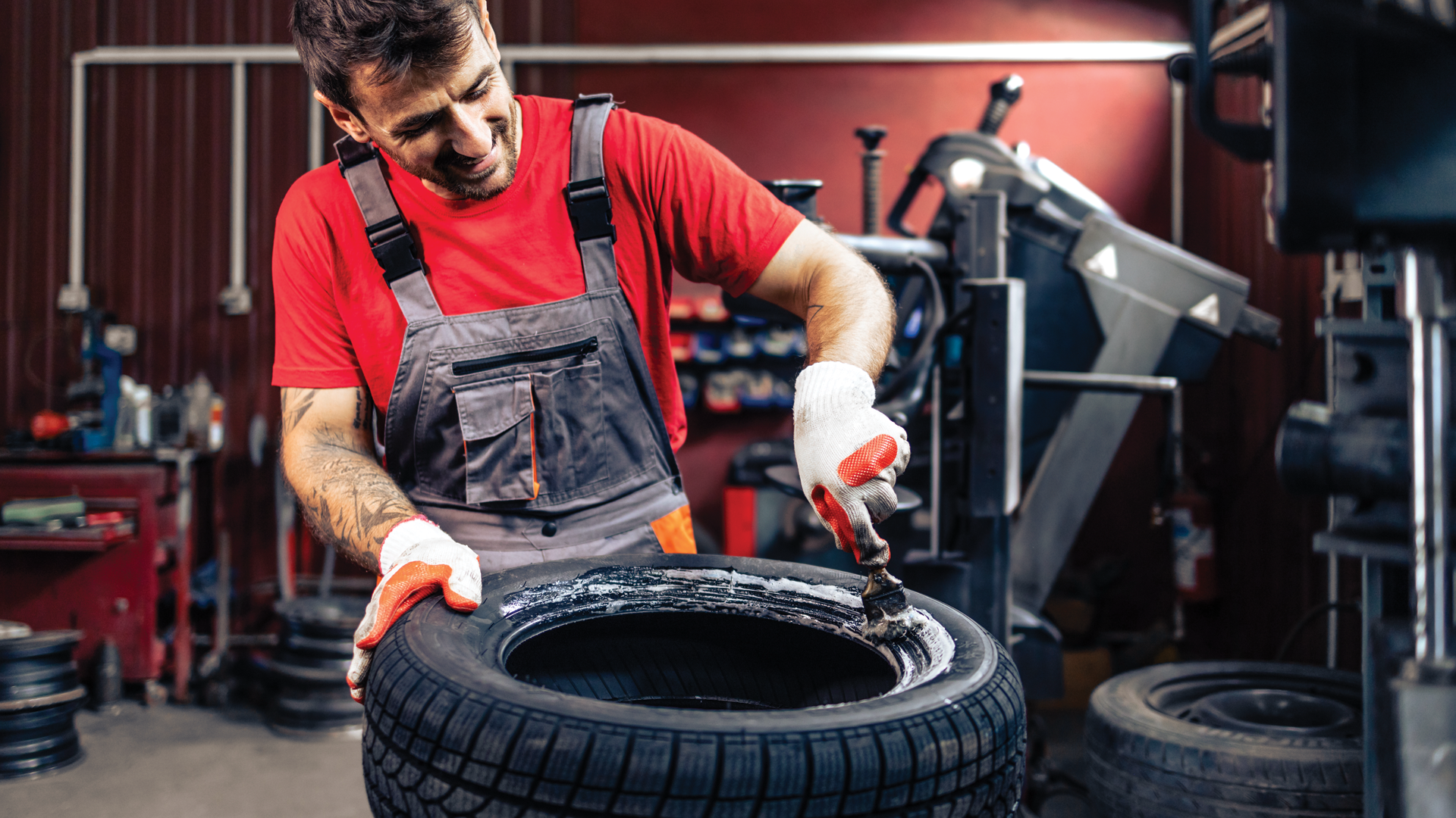 A man is working on a tire in a garage.
