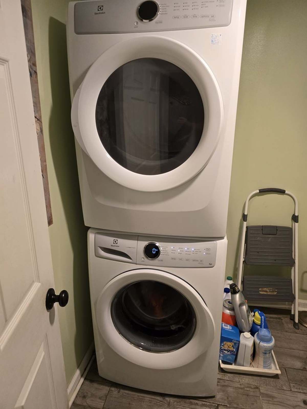 A washer and dryer are stacked on top of each other in a laundry room.