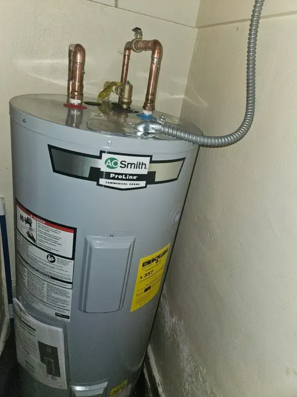 An AO Smith water heater in a corner, with copper pipes and electrical conduit.