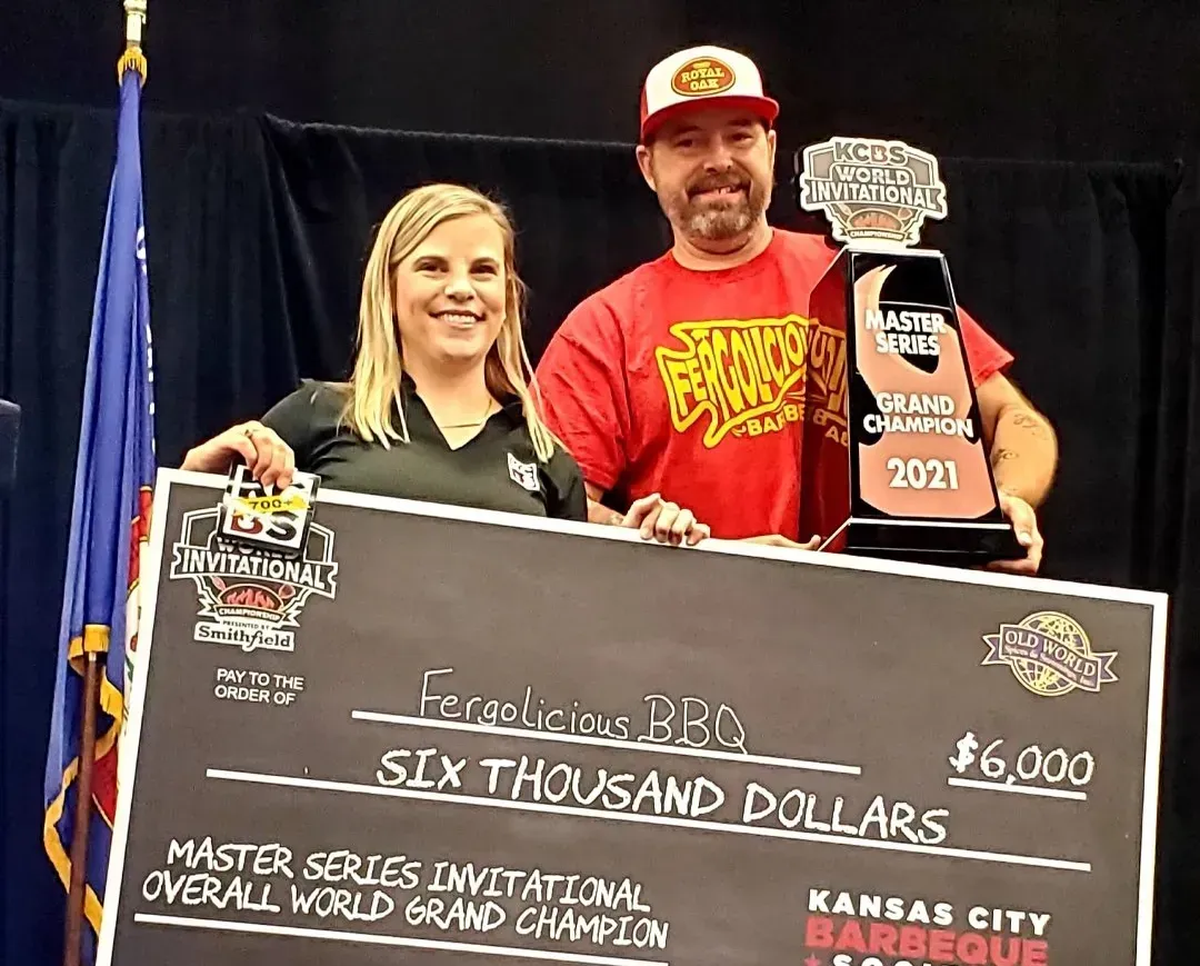 A man and a woman are holding a six thousand dollar check.