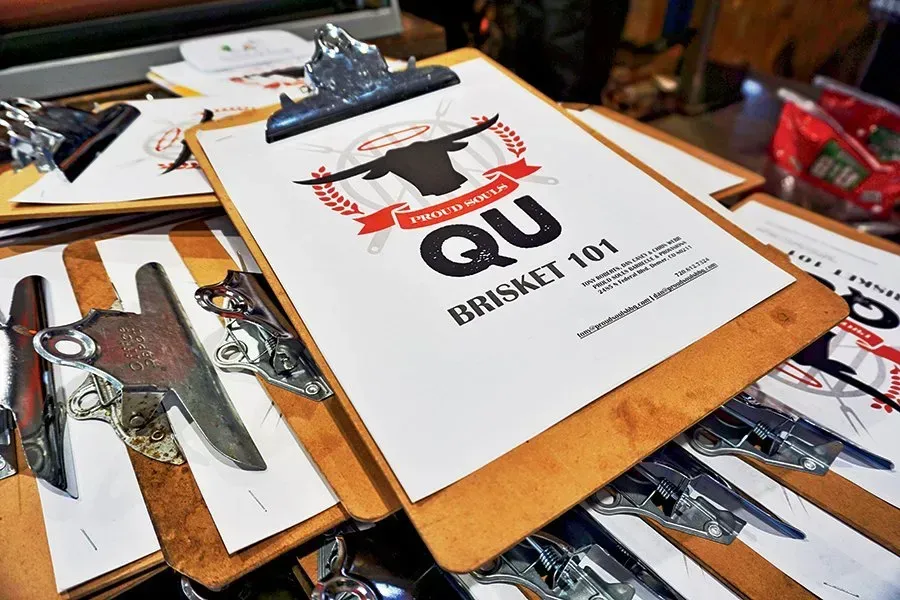 A clipboard with the words qu brisket 101 on it