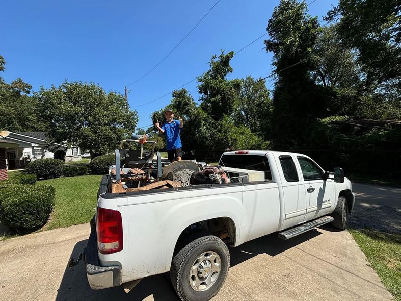 A man is standing on the back of a white truck.