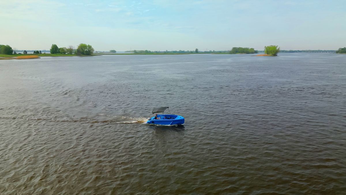 Blue Phantom plastic boat in middle of river