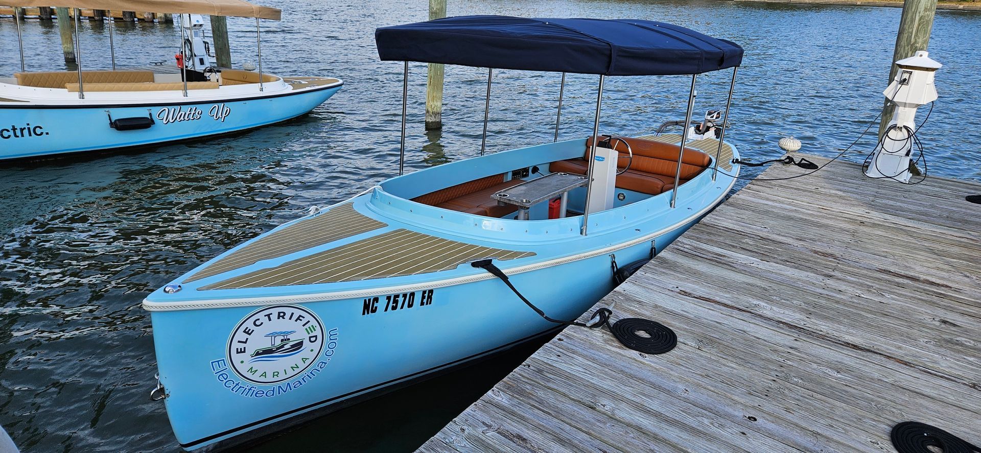 Blue Fantail boat with blue canopy top - port side tied to dock