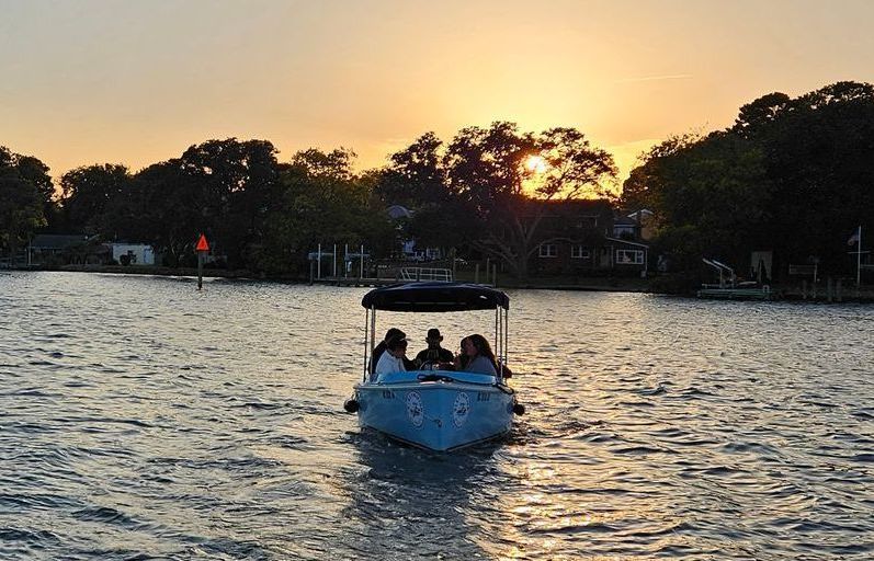 Blue Fantail boat with blue canopy top - sunset