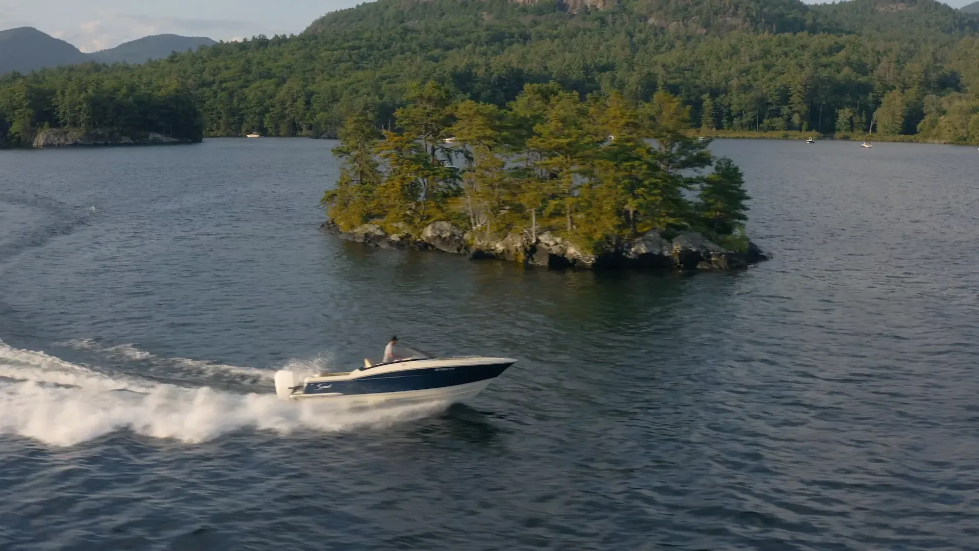 Blue scout dorado speed through water bow rider in front of island/inlet