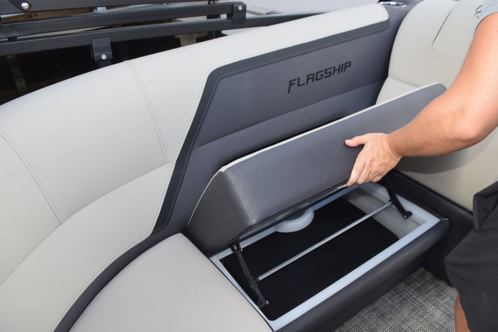 Women opening up under seat storage on Flagship Discover pontoon