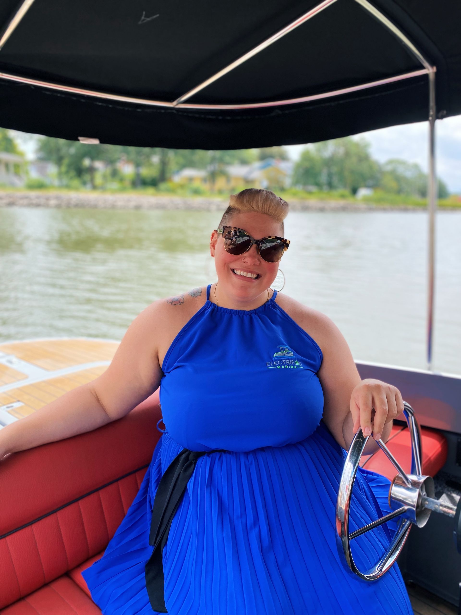 A woman in a blue dress is sitting on a boat