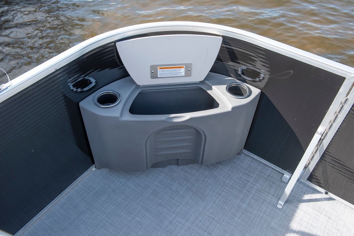 Storage in corner of a pontoon opened showing space to keep  dock lines, fenders,towels, etc