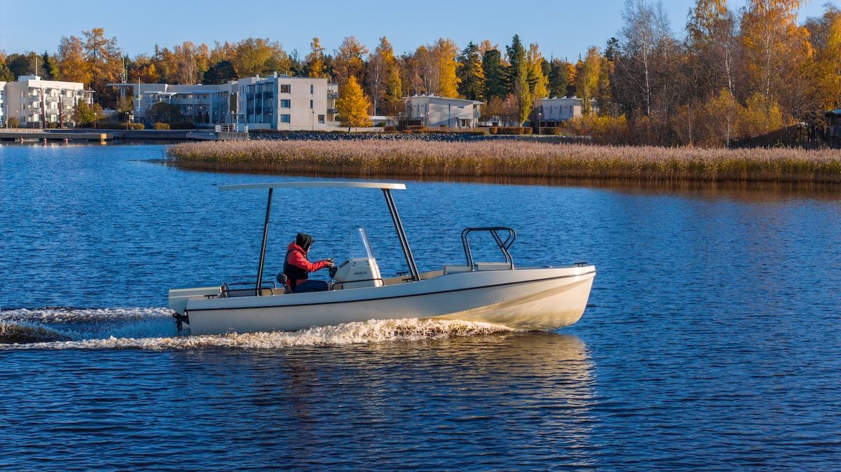 single person in captain chair of Amber from Elvene boats building and foliage in background