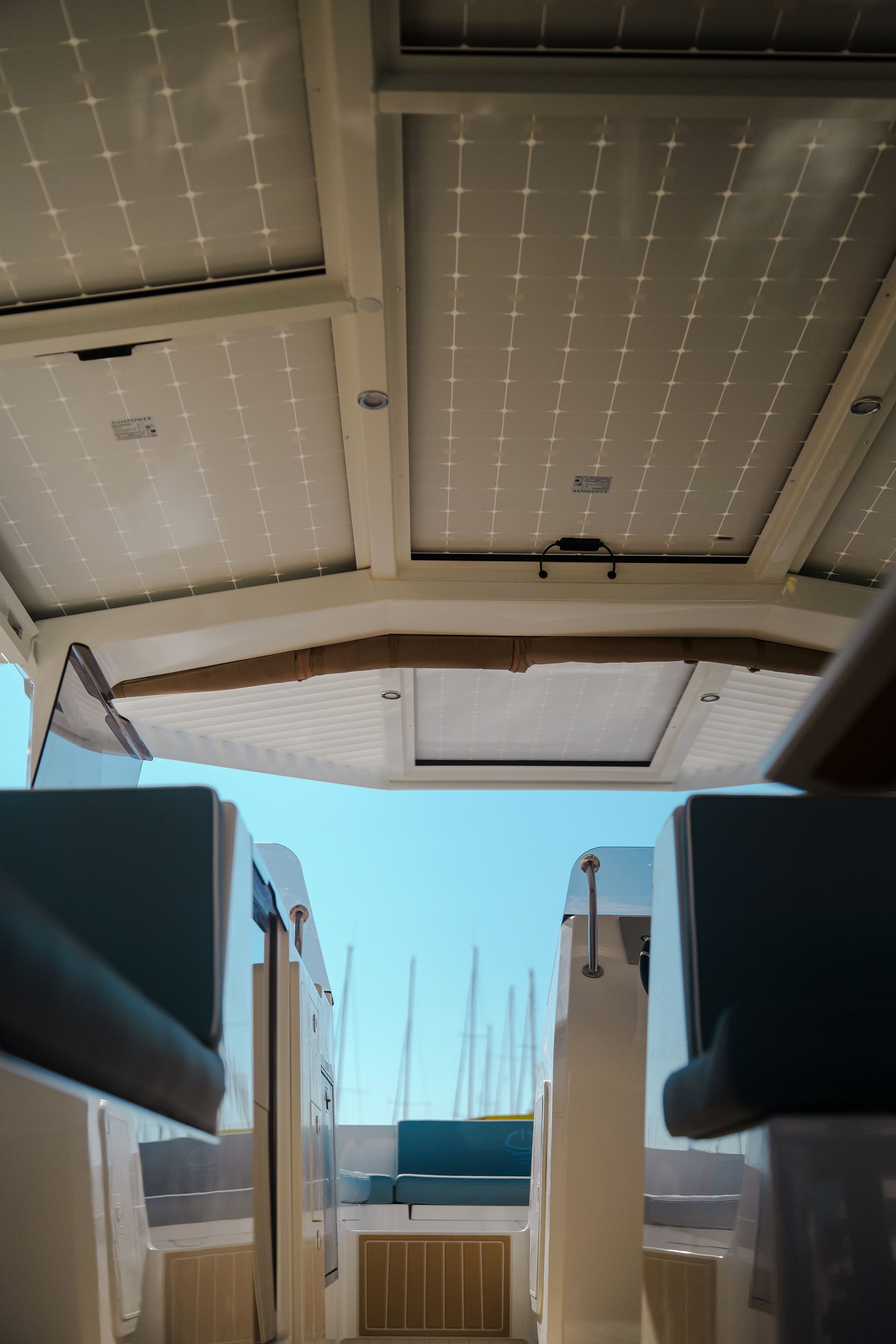 Walkway on boat with solar panels on roofs blue cushions on seats