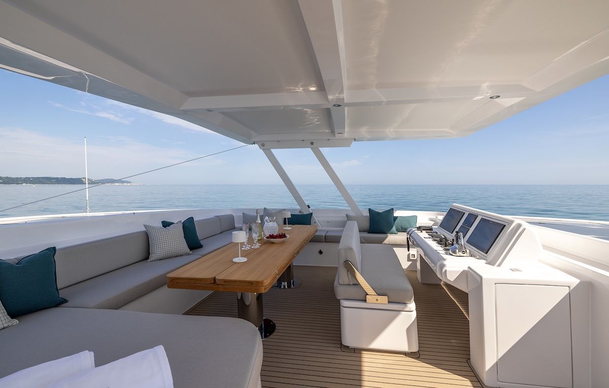 Stella electric 62 yacht flybridge with water in background and table and wrap around seating