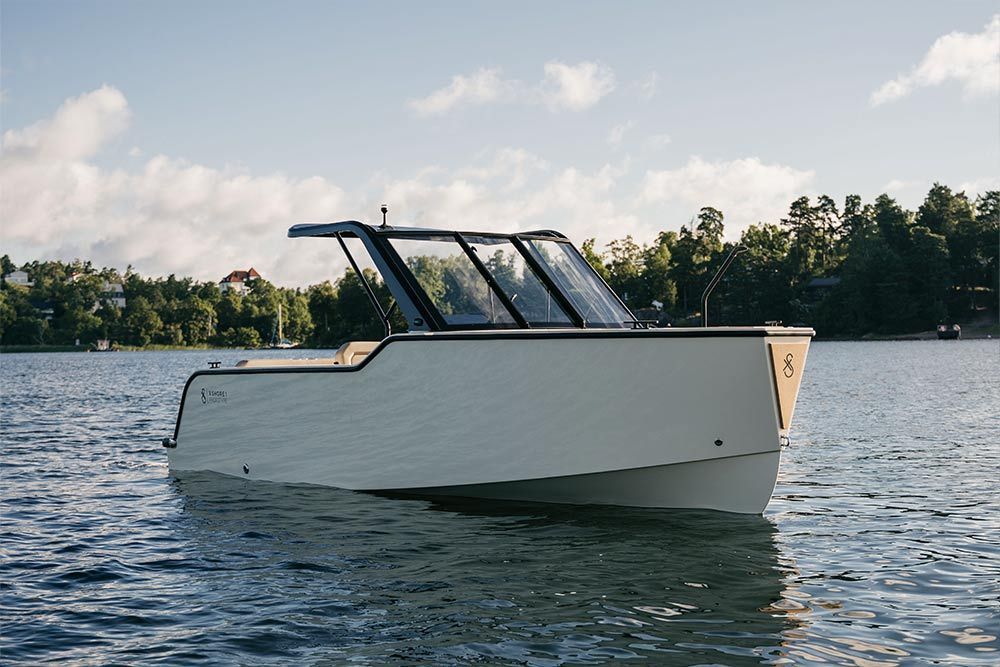 A white boat is floating on top of a lake.