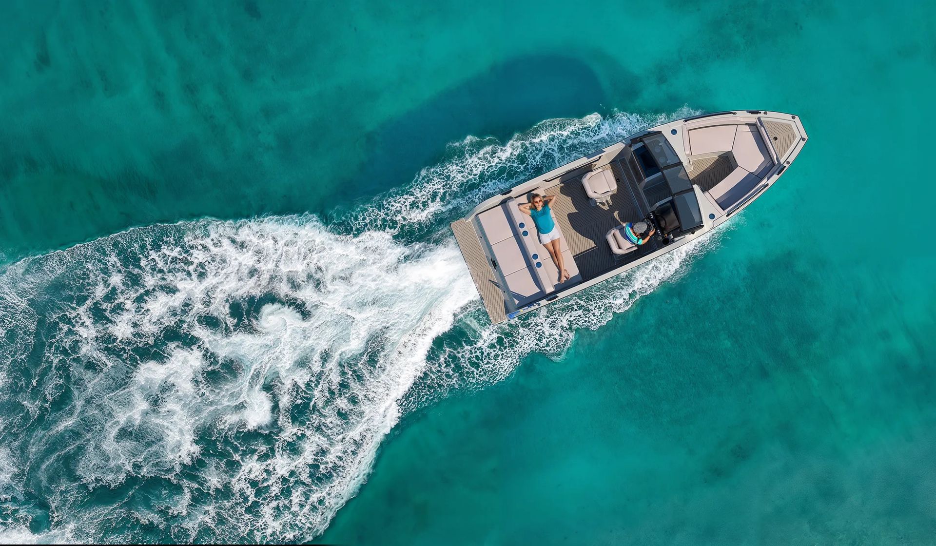 An electric X Shore boat  bowrider is racing on top of a body of water.
