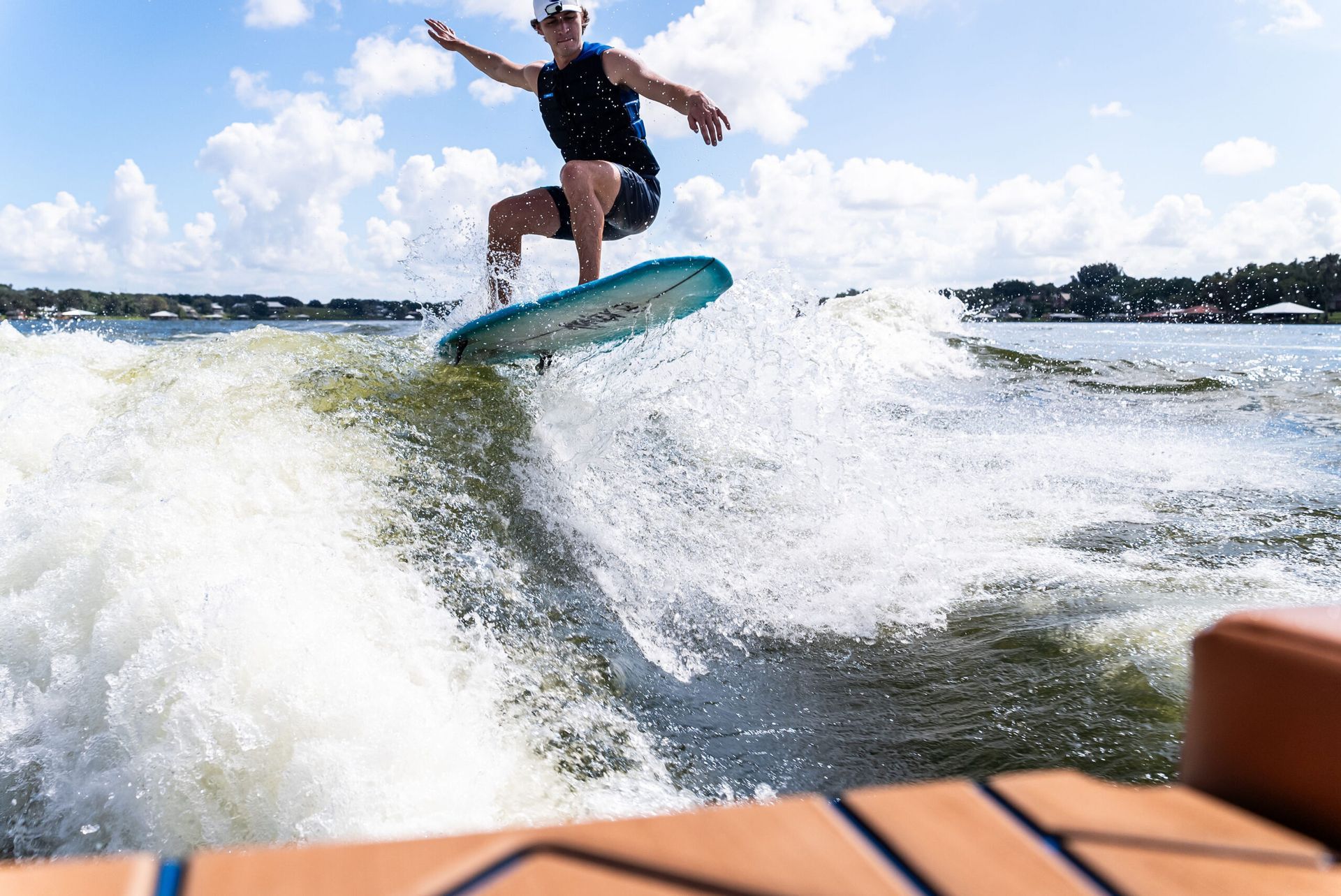 wakesurfer catching wave blue board wake boarding boat hybrid genesis24 wakesurfing boat