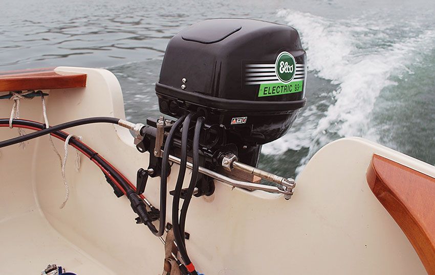 A Black electric boat motor hanging off the stern of a boat