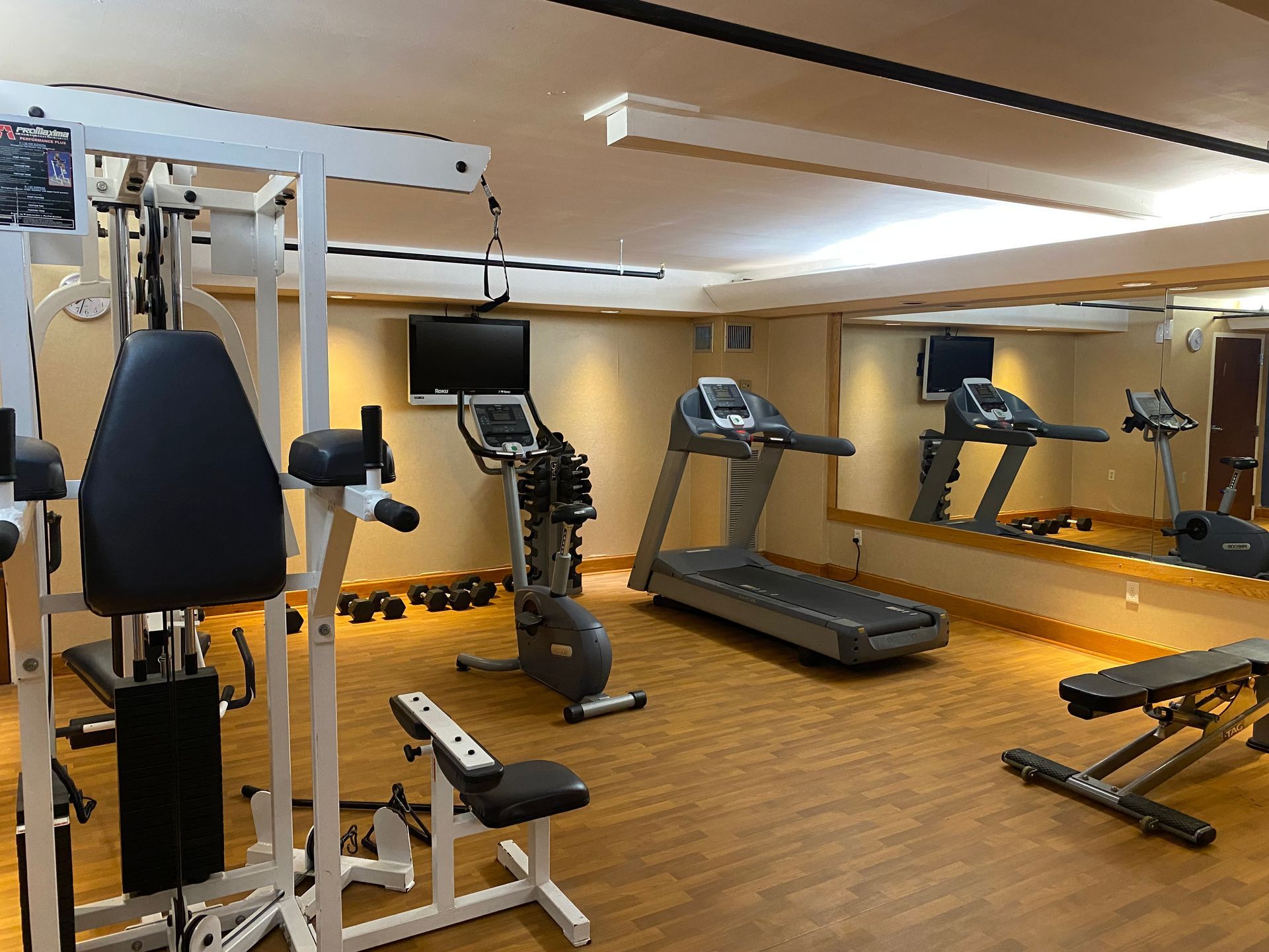 A gym with treadmills , exercise bikes , and a bench.