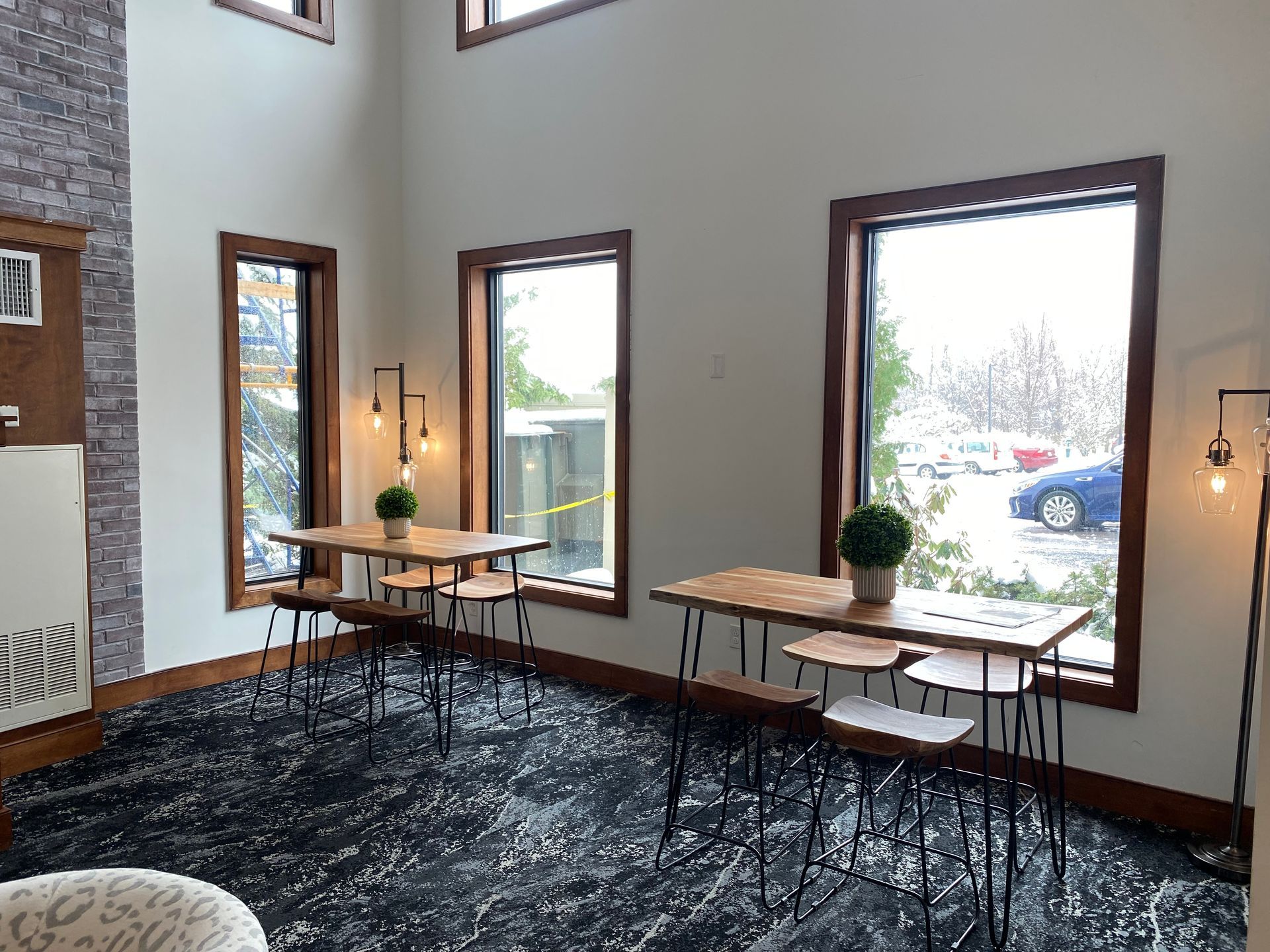 A room with tables and chairs and a lot of windows.