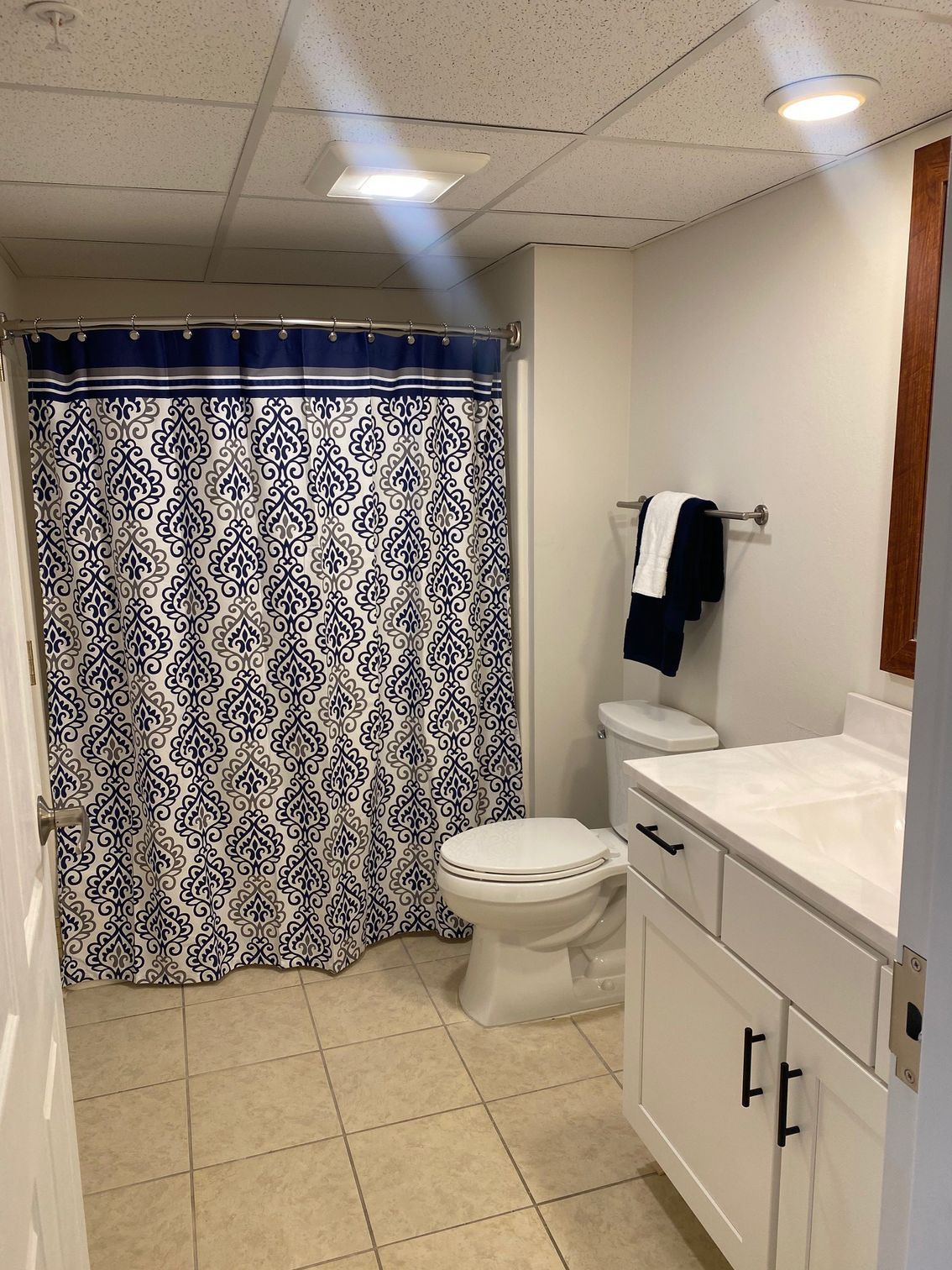 A bathroom with a toilet , sink and shower curtain