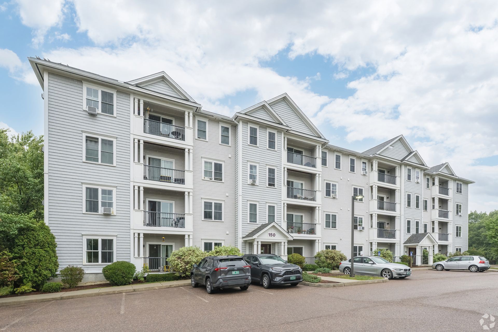 A large apartment building with cars parked in front of it