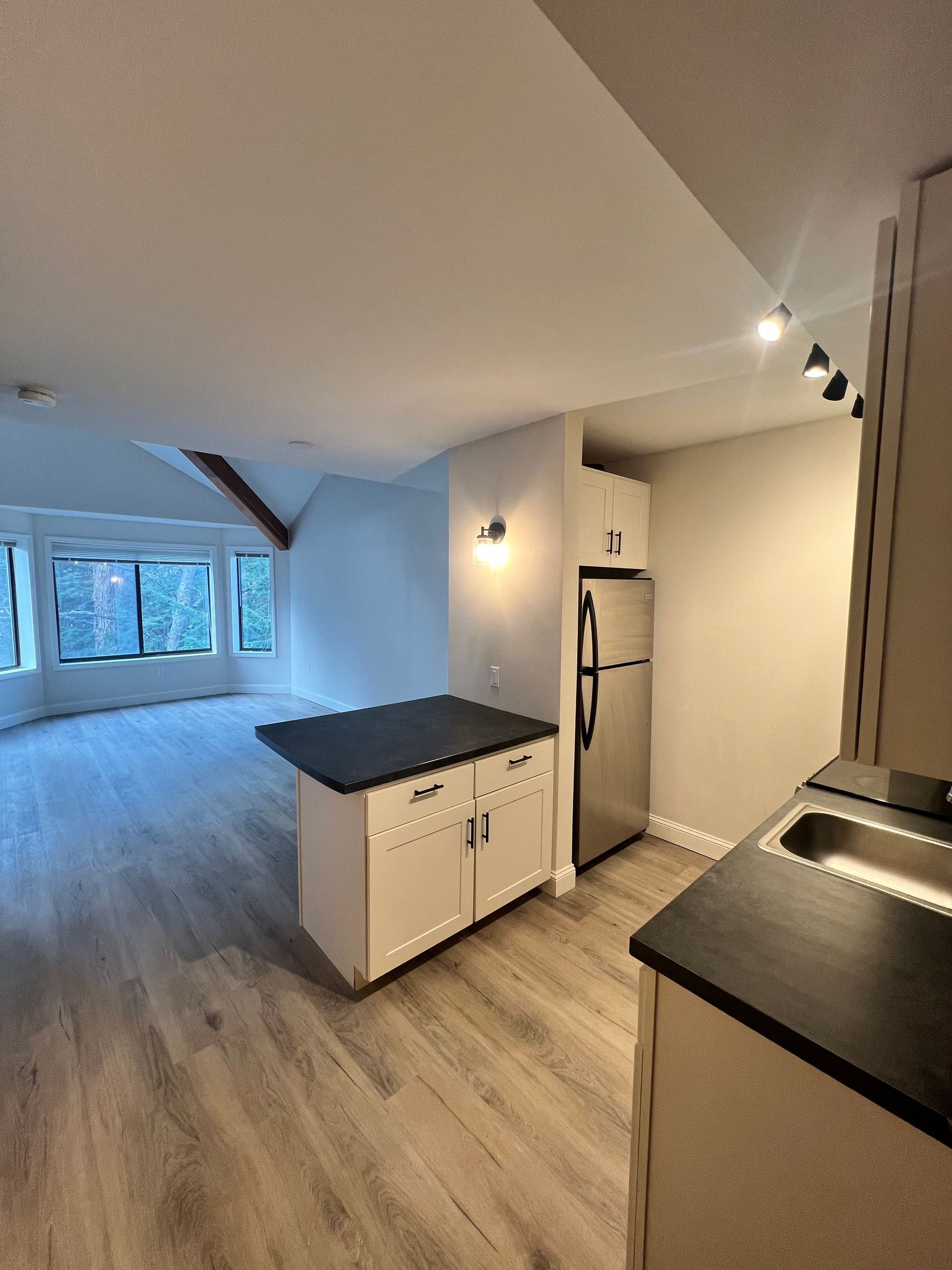 A kitchen with a stainless steel refrigerator and a sink.