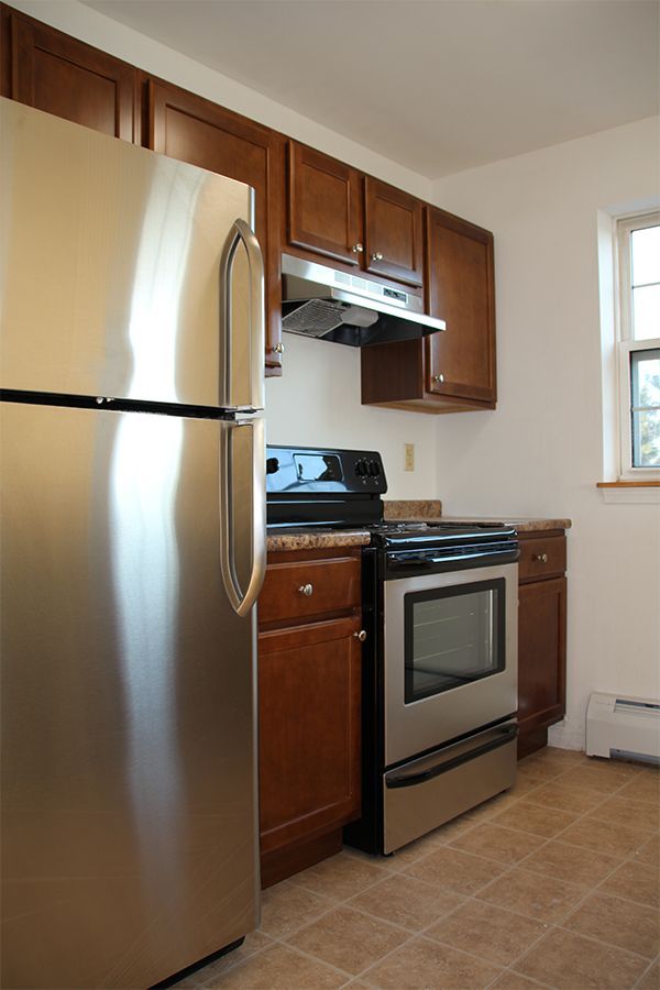 A kitchen with stainless steel appliances and wooden cabinets