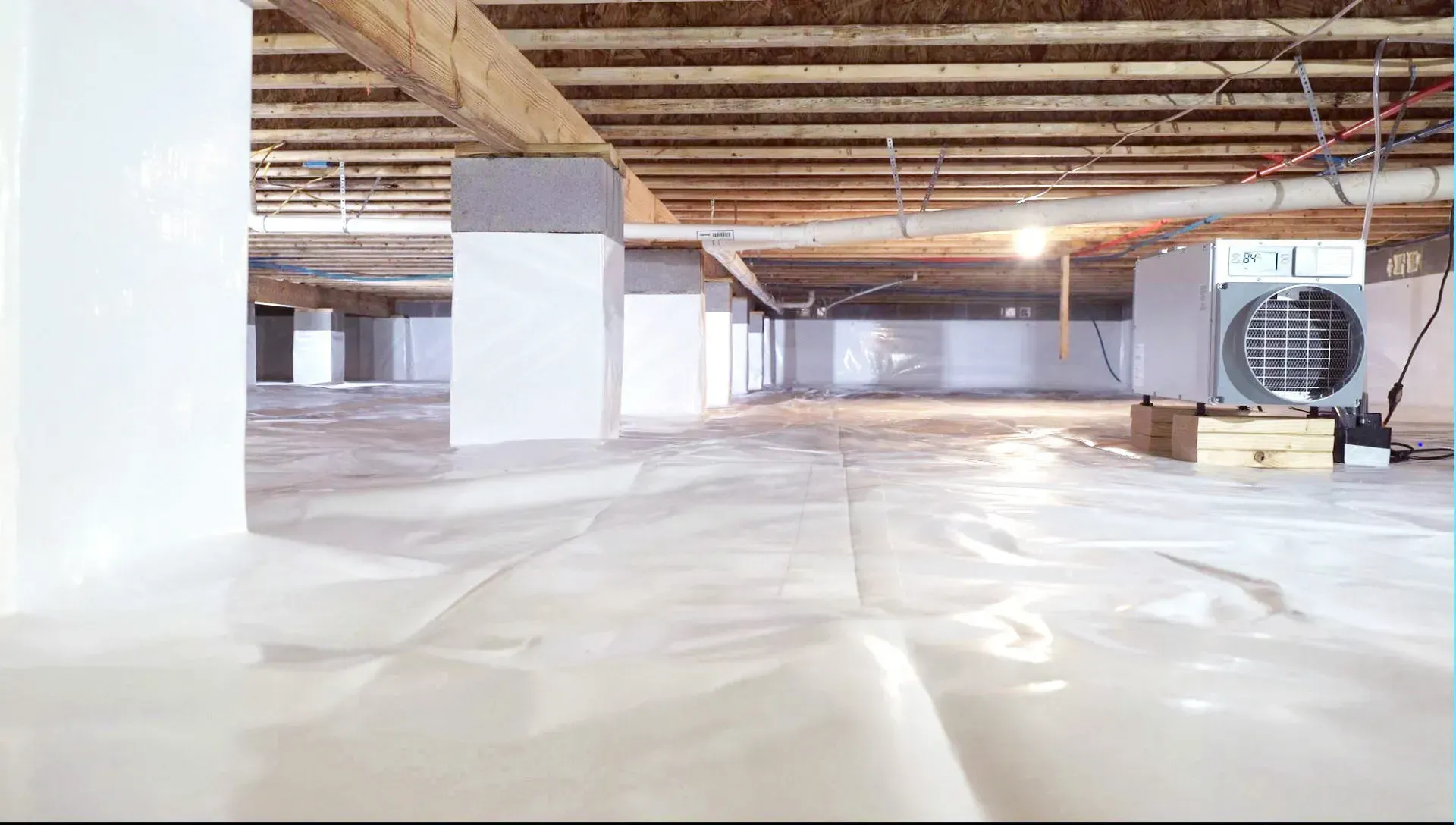 A very large empty basement with a heater on the floor.