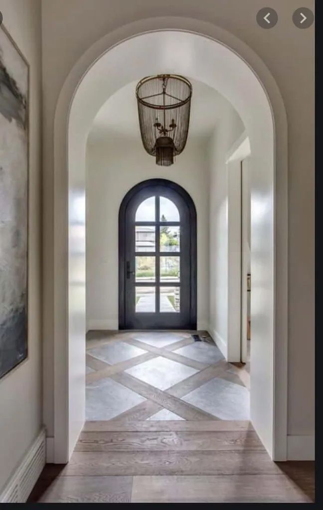 A hallway with a black door and a lantern hanging from the ceiling.